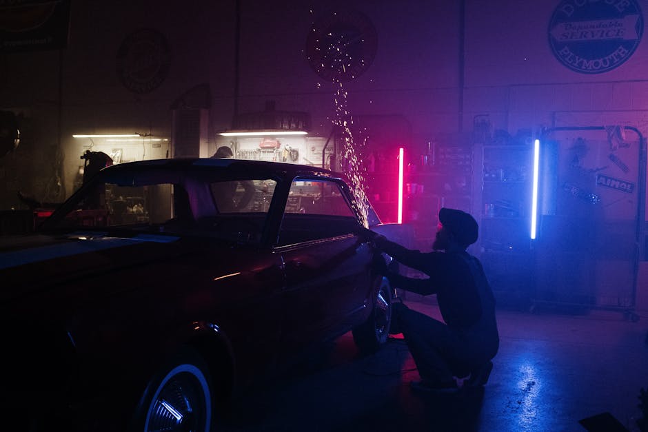 A mechanic working with sparks under neon lights in a garage, showcasing auto repair artistry.